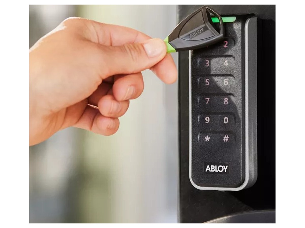 Abloy Pulse -avain ja kulkutunniste kädessä